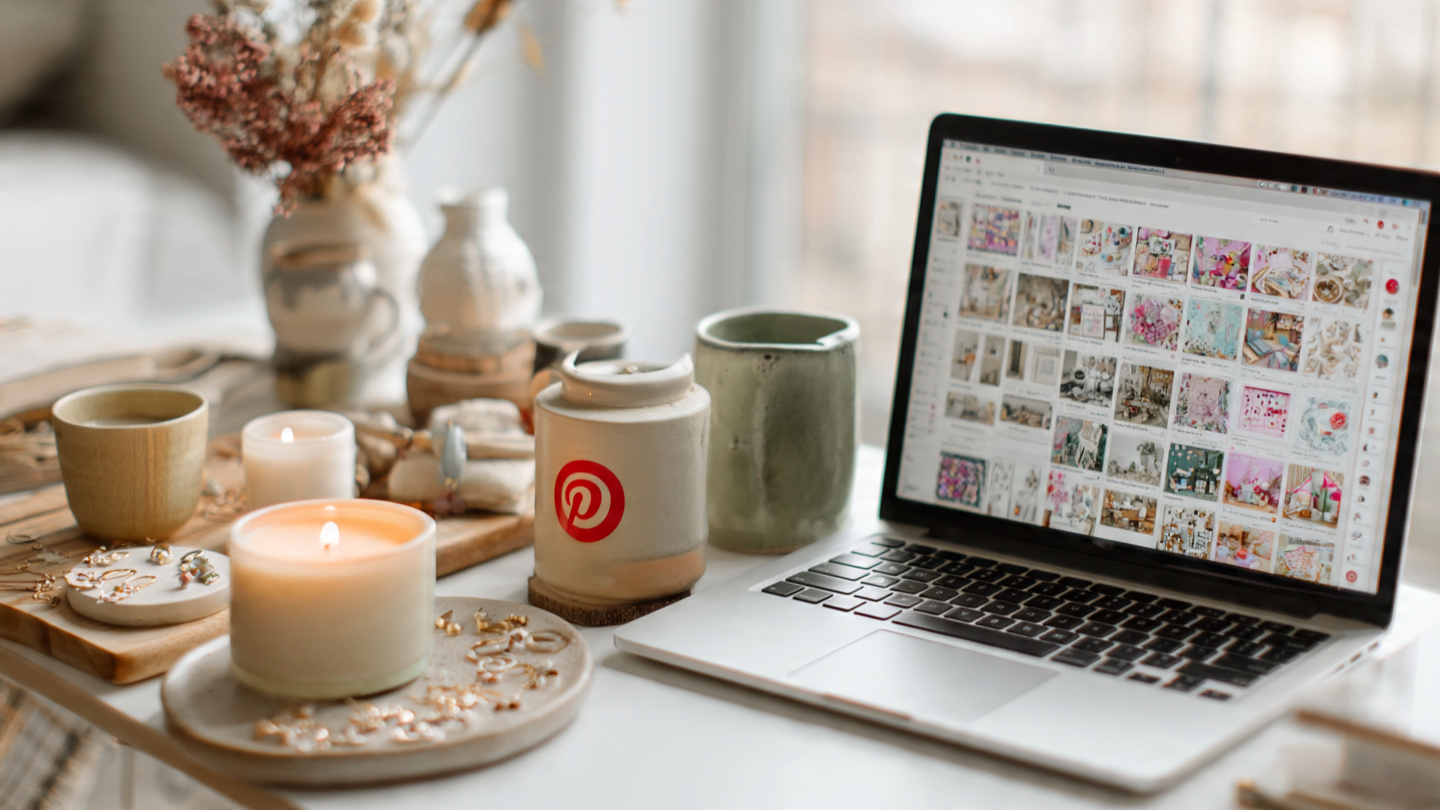 Handmade products beside a laptop showing Etsy product pins on Pinterest